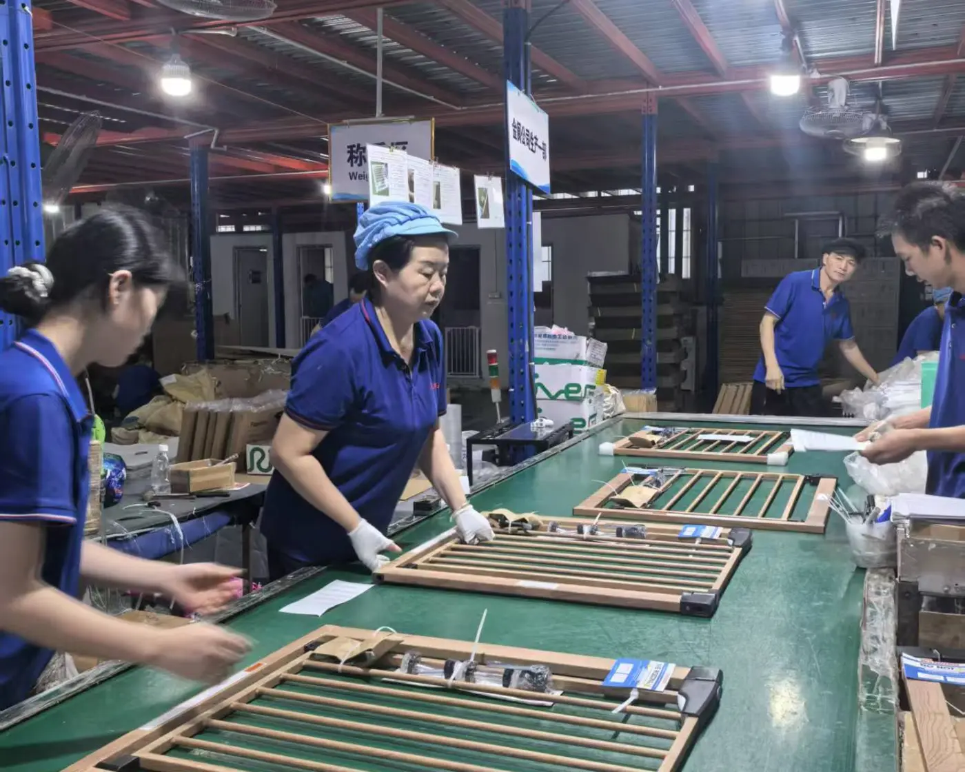 Jinlang production team assembling and preparing wood-and-steel baby gates for pack-out