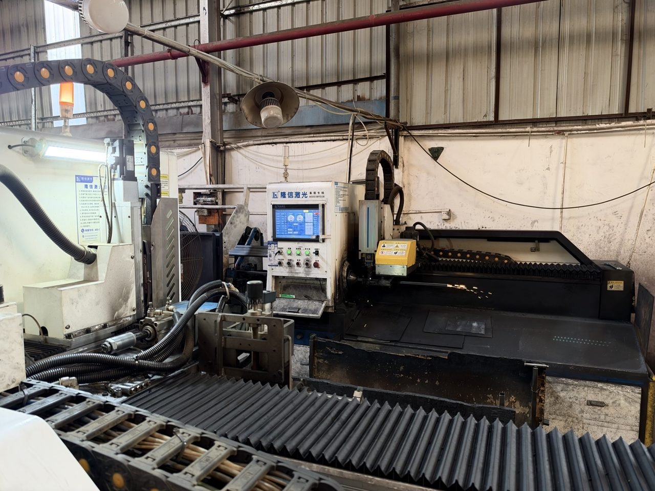 Laser cutting equipment operating in a metal-processing workshop