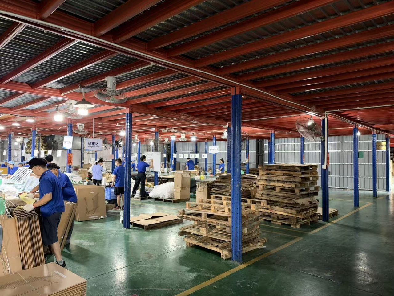 Workers handling cartons and packing materials in a baby gate workshop